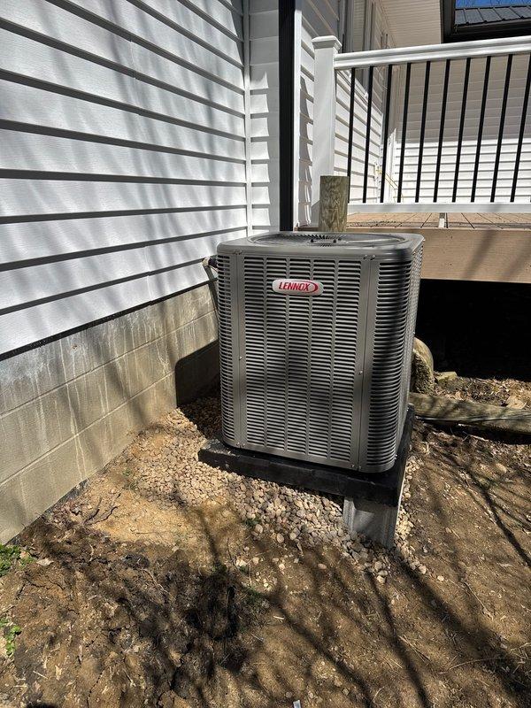 Completed new construction HVAC installation including refrigerant line set, outdoor condensing unit, and final system commissioning. Installed Lennox air conditioning condenser on elevated pad with proper foundation support, ran electrical conduit and refrigerant lines to exterior wall penetration, and verified all connections for proper operation. System tested and left operational for customer use.