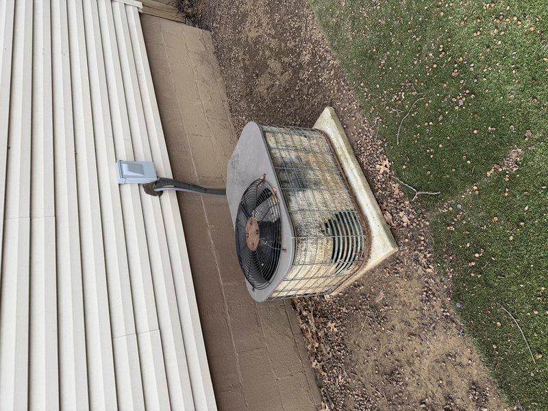 Completed AC retrofit installation including outdoor condenser unit and indoor evaporator coil. Positioned new condenser on existing concrete pad adjacent to building, secured electrical conduit to exterior siding, and connected refrigerant lines. Installed new evaporator coil in basement utility area, integrated with existing furnace system, and connected metallic supply ductwork. Tested system operation, verified proper refrigerant charge, confirmed adequate airflow, and ensured all electrical connections met code requirements. System operational and cooling effectively upon completion.