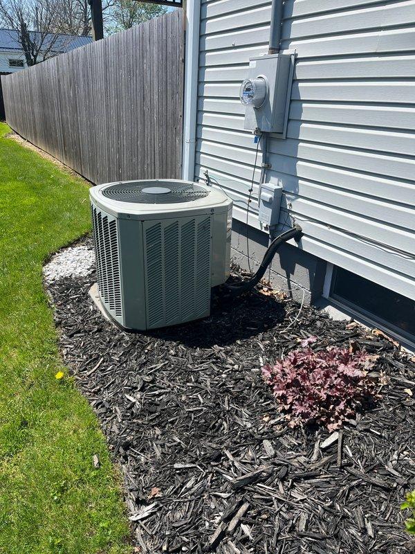 Completed comprehensive estimate for residential HVAC system replacement, including outdoor air conditioning unit and indoor furnace. Assessed existing cylindrical AC condenser with green metal casing located on exterior mulch bed, evaluated electrical connections and conduit routing on home's exterior wall. Inspected basement mechanical room to assess furnace replacement requirements, documented water heater proximity and existing ductwork configuration with metallic supply and return runs. Captured detailed documentation of both outdoor and indoor equipment locations to provide accurate replacement proposal for complete heating and cooling system upgrade.