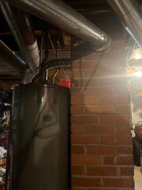 Completed comprehensive estimate for residential HVAC system replacement, including outdoor air conditioning unit and indoor furnace. Assessed existing cylindrical AC condenser with green metal casing located on exterior mulch bed, evaluated electrical connections and conduit routing on home's exterior wall. Inspected basement mechanical room to assess furnace replacement requirements, documented water heater proximity and existing ductwork configuration with metallic supply and return runs. Captured detailed documentation of both outdoor and indoor equipment locations to provide accurate replacement proposal for complete heating and cooling system upgrade.