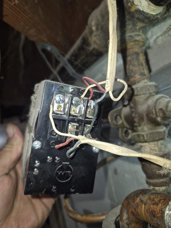 Responded to service call for reported boiler leak in basement mechanical area. Upon inspection, discovered significant corrosion and oxidation on copper piping assembly, particularly on bypass loop configuration with visible green patina at multiple joints and connection points. Assessed electrical relay component connected to circulator pump system, noting age-related wear on terminals and wiring connections. Documented extensive deterioration of mechanical system components including corroded piping and aging control devices. Photographed affected areas showing compromised copper pipe integrity and electrical connections for repair recommendations. System requires replacement of corroded copper piping sections and evaluation of pump relay functionality to restore proper operation and eliminate active leak source.