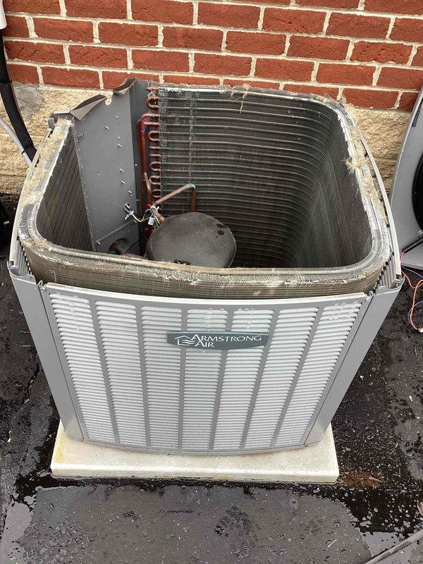 Completed spring maintenance on Armstrong commercial air conditioning unit. Removed top access panel and performed comprehensive inspection of condenser coil, compressor, capacitor, and electrical connections. All internal components found in serviceable condition with proper wiring configuration. Documented unit condition with photos showing accessible condenser coil assembly, copper refrigerant lines, and electrical control panel with capacitor and circuit board connections.