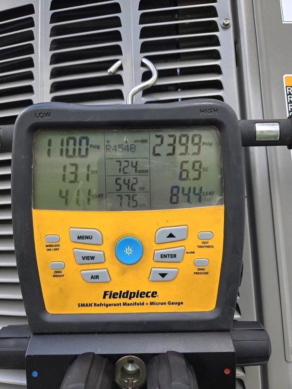 Responded to service call for non-operational air conditioning system on recent installation. Upon arrival, performed diagnostic testing using refrigerant manifold and micron gauge to assess system pressures and verify proper refrigerant charge levels. Inspected internal components including drain pump assembly and electrical connections. System pressures measured at 110.0 psig on low side and 239.9 psig on high side during testing. Verified all mechanical and electrical components were properly secured and functioning. System restored to normal operation.