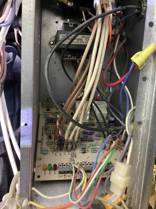 Responded to service call for overheating compressor on commercial air conditioning system. Upon arrival, accessed HVAC control panel and performed diagnostic inspection of electrical components and control board. Verified proper LED indicator status and examined wiring connections, transformer, and relay components for signs of electrical issues or heat damage. Inspected ceiling-mounted air handling equipment in plenum space above drop ceiling to assess compressor condition and related mechanical systems. Documented equipment condition with photos for service records.
