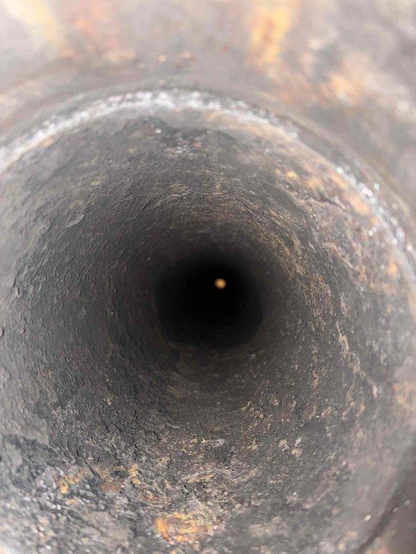 Performed comprehensive cleaning of heavily soiled heat exchanger tubes showing significant soot, debris, and corrosion buildup that was restricting proper airflow and combustion efficiency. Removed existing deteriorated exhaust venting system and installed new B-vent exhaust piping to ensure safe and code-compliant venting of combustion gases from the commercial HVAC unit.