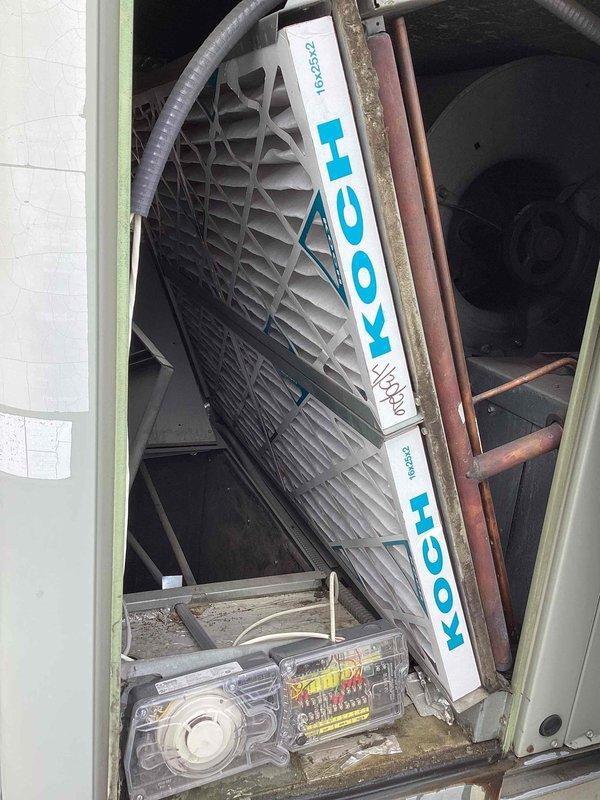 Performed comprehensive clean and check service on commercial rooftop HVAC unit. Inspected evaporative cooling system with diamond-pattern grille and verified proper operation of all mechanical components including fan assembly and refrigerant lines. Replaced four air filters in the intake housing—two larger upper filters and two smaller lower filters—ensuring proper airflow and system efficiency. Cleaned exterior surfaces, checked electrical connections, and confirmed all copper piping connections were secure with no visible leaks or damage.