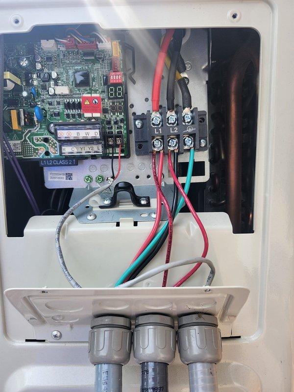 Coordinated with security alarm company on-site to address condenser wiring integration after removal of previous system. Completed electrical connections at outdoor condensing unit, properly terminating power and control wiring to terminal block within disconnect enclosure, and documented installation of control board with associated low-voltage connections for alarm system interface.