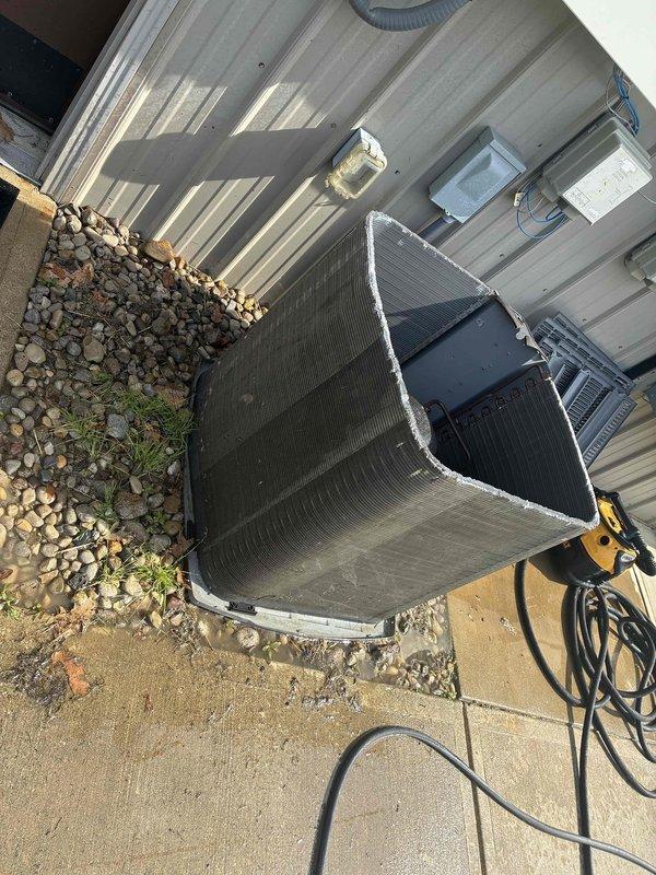 Completed spring maintenance on commercial outdoor air conditioning condenser unit. Performed comprehensive system inspection including visual assessment of condenser coils, which showed moderate accumulation of dirt, grime, and surface discoloration requiring attention. Checked all electrical connections, disconnect box, and conduit mounting at exterior wall. Inspected compressor, refrigerant lines, and internal components for proper operation and signs of wear. Verified unit mounting on concrete pad and surrounding area conditions. System operational upon completion of scheduled maintenance protocol.