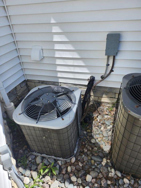Completed full second-floor air conditioning system replacement including outdoor condensing unit and indoor evaporator coil. Installed new condenser on existing rock pad against building exterior with proper clearances, connected refrigerant line sets with fresh insulation, and mounted weatherproof electrical disconnect box on exterior wall. Inside mechanical space, installed new evaporator coil with air handler unit, ran condensate drain lines using PVC piping, and completed all electrical connections and ductwork integration to existing distribution system.