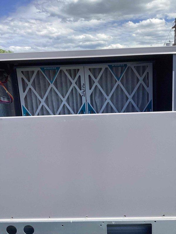 Performed routine commercial cooling maintenance on rooftop HVAC unit. Inspected and documented three KOCH pleated air filters installed in filter rack, all showing proper installation and condition. Recorded temperature measurements using digital instrument, with reading of 92.1°F indicating normal operating parameters for system performance during visit.