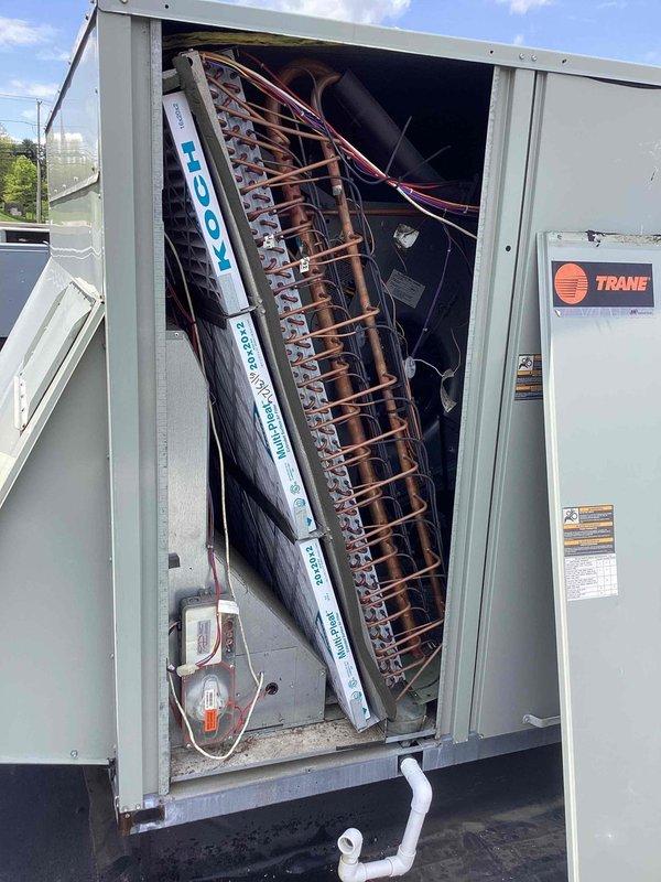 Completed spring maintenance on rooftop-mounted Trane commercial HVAC unit. Performed comprehensive inspection of copper coil assembly, electrical connections, and all mechanical components. Unit found in good operating condition with clean coils and properly functioning systems. Documented equipment condition with photos showing interior components and exterior unit placement.