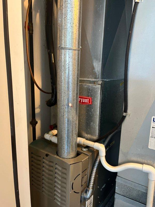 Completed air conditioning retrofit installation in residential mechanical room. Installed new Bryant HVAC system including air handler unit with associated ductwork connections and condensate drainage lines. The existing vertical galvanized supply duct was integrated with the new equipment, and all electrical connections and refrigerant lines were properly secured and routed. System was tested and confirmed operational upon completion.