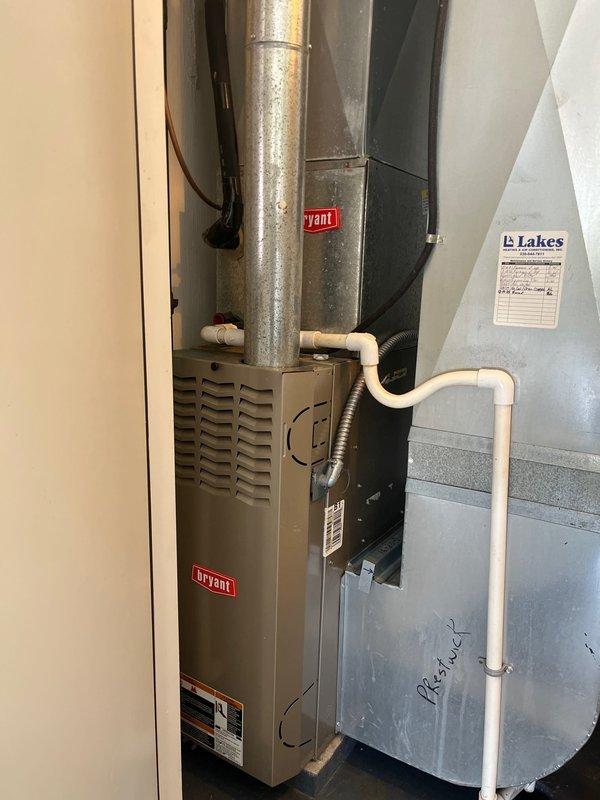 Completed air conditioning retrofit installation in residential mechanical room. Installed new Bryant HVAC system including air handler unit with associated ductwork connections and condensate drainage lines. The existing vertical galvanized supply duct was integrated with the new equipment, and all electrical connections and refrigerant lines were properly secured and routed. System was tested and confirmed operational upon completion.