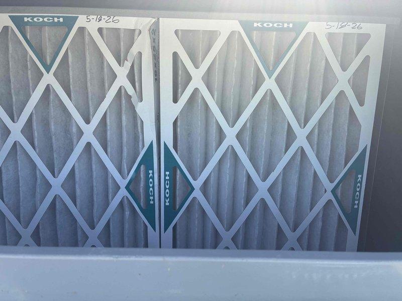Completed spring maintenance on commercial rooftop HVAC unit. Replaced two KOCH brand pleated air filters that showed moderate dirt accumulation and discoloration from normal service use. Inspected condenser coil and noted visible buildup of dirt, dust, and debris on fins requiring attention during routine maintenance visit.