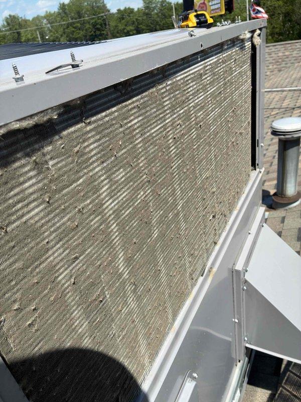 Completed spring maintenance on commercial rooftop HVAC unit. Replaced two KOCH brand pleated air filters that showed moderate dirt accumulation and discoloration from normal service use. Inspected condenser coil and noted visible buildup of dirt, dust, and debris on fins requiring attention during routine maintenance visit.