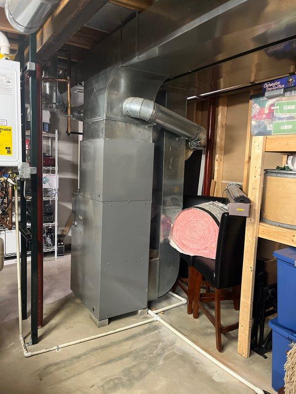 Completed comprehensive HVAC system assessment for air conditioning retrofit in residential basement utility space. Evaluated existing furnace and air handler configuration, including ductwork connections, electrical components, and system accessibility for planned AC integration. Documented current equipment layout, clearances, and mechanical room conditions to determine optimal retrofit approach for new cooling system installation.