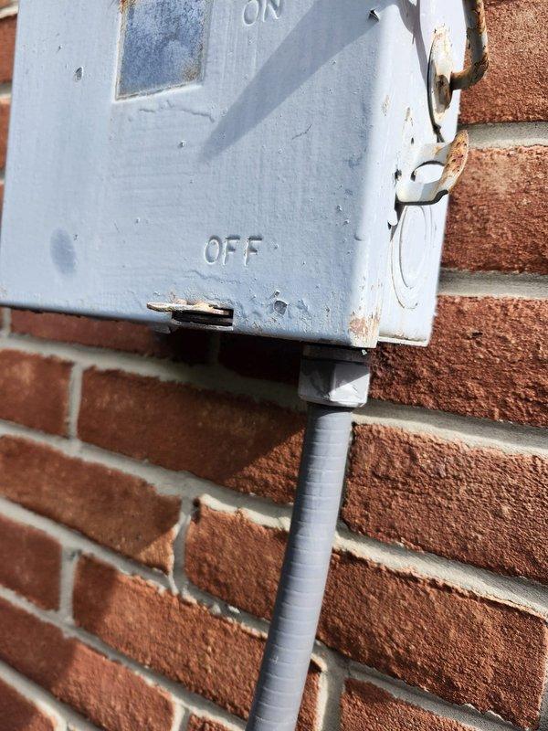 Responded to no-heat call for commercial furnace unit serving apartment 3A, located in third-floor hallway adjacent to elevator. Upon arrival, inspected electrical disconnect box mounted on exterior brick wall and found deteriorated wiring connections with visible corrosion inside junction box. Documented existing conditions showing compromised wire nuts, exposed conductors including green grounding wires, and weathered enclosure with rust damage affecting electrical integrity. The unit's failure to operate was attributed to faulty electrical supply connections requiring immediate attention to restore power and functionality to the heating system.