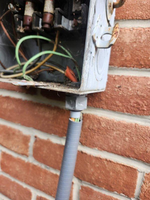 Responded to no-heat call for commercial furnace unit serving apartment 3A, located in third-floor hallway adjacent to elevator. Upon arrival, inspected electrical disconnect box mounted on exterior brick wall and found deteriorated wiring connections with visible corrosion inside junction box. Documented existing conditions showing compromised wire nuts, exposed conductors including green grounding wires, and weathered enclosure with rust damage affecting electrical integrity. The unit's failure to operate was attributed to faulty electrical supply connections requiring immediate attention to restore power and functionality to the heating system.