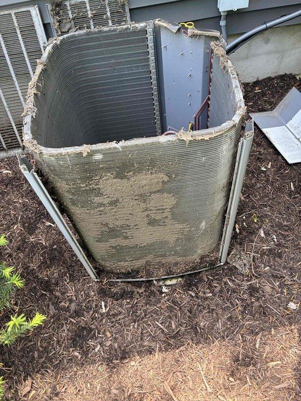 Completed spring maintenance on commercial HVAC condenser unit. Upon inspection, found extensive deterioration of exterior casing with protective grille material compromised and torn away, exposing internal components to weather and debris. Unit exterior exhibited heavy accumulation of dirt, grime, and biological growth requiring thorough cleaning. Interior inspection revealed significant mineral deposits and corrosion on compressor mounting base, along with debris accumulation throughout cabinet. Cleaned condenser coils, removed debris from unit interior, and inspected refrigerant lines and electrical connections for integrity. Documented unit condition with photographs due to advanced deterioration of cabinet requiring replacement recommendation.