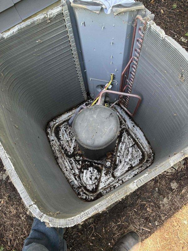 Completed spring maintenance on commercial HVAC condenser unit. Upon inspection, found extensive deterioration of exterior casing with protective grille material compromised and torn away, exposing internal components to weather and debris. Unit exterior exhibited heavy accumulation of dirt, grime, and biological growth requiring thorough cleaning. Interior inspection revealed significant mineral deposits and corrosion on compressor mounting base, along with debris accumulation throughout cabinet. Cleaned condenser coils, removed debris from unit interior, and inspected refrigerant lines and electrical connections for integrity. Documented unit condition with photographs due to advanced deterioration of cabinet requiring replacement recommendation.