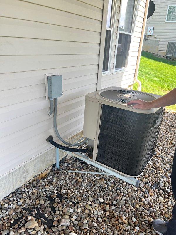 Completed full HVAC system retrofit in residential basement, replacing existing furnace and air conditioning equipment. Installed new Lennox furnace unit with proper connection to existing ductwork system including pyramidal plenum and galvanized metal distribution runs. Exterior installation included new air conditioning condenser unit positioned on decorative rock bed with proper electrical disconnect box and conduit routing along house exterior. Verified all refrigerant line connections, electrical components, and system controls for proper operation upon completion.