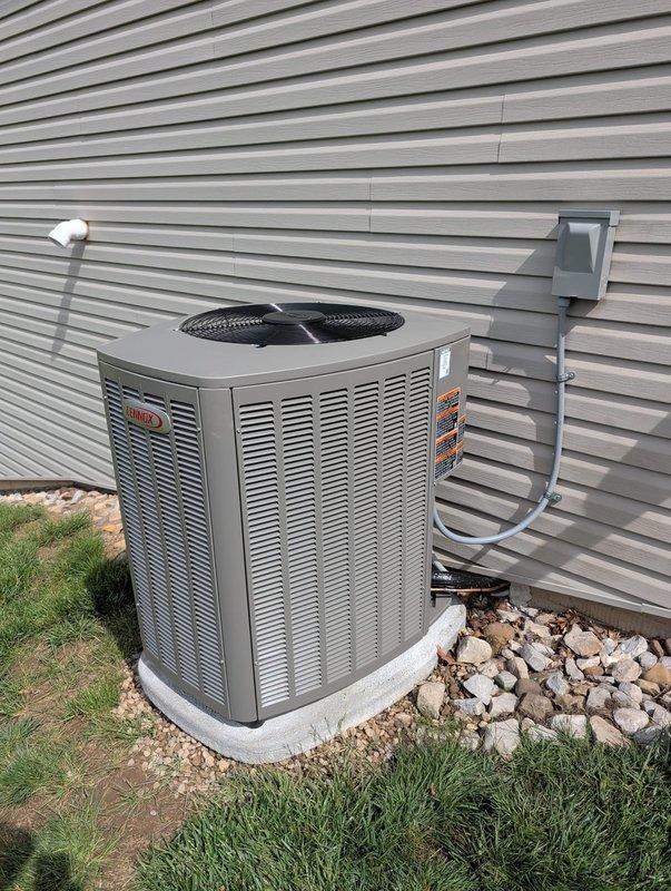 Completed full AC retrofit installation including new Lennox outdoor condensing unit and indoor evaporator coil. Removed existing equipment and installed new air handler with coil in basement utility area, connecting to existing ductwork via galvanized metal transitions. Mounted new Lennox condensing unit on concrete pad outside with proper clearances from building structure. Installed electrical disconnect box on exterior wall with conduit run from unit to disconnect. Connected refrigerant lines between indoor and outdoor units, evacuated system, and charged to manufacturer specifications. Verified all electrical connections, tested system operation through complete cooling cycle, and confirmed proper airflow and temperature differential across coil.