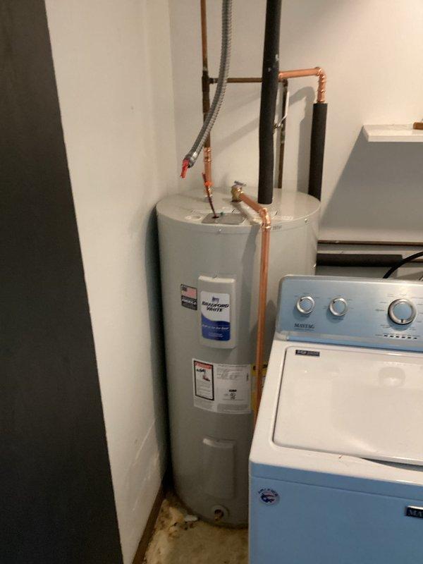 # Plumbing Install - Tanked Water Heater

Successfully installed two 40-gallon electric Bradford White water heaters in the utility room. The installation included proper copper piping connections for hot and cold water lines, installation of required safety valves, and flexible supply lines where appropriate. All plumbing connections were secured and tested for leaks, with the units positioned to allow adequate clearance for maintenance access. The water heaters were installed according to manufacturer specifications and local plumbing codes, with electrical connections completed to ensure safe operation. System was fully tested and confirmed operational upon completion.