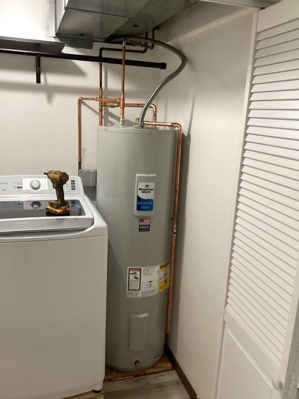 # Plumbing Install - Tanked Water Heater

Successfully installed two 40-gallon electric Bradford White water heaters in the utility room. The installation included proper copper piping connections for hot and cold water lines, installation of required safety valves, and flexible supply lines where appropriate. All plumbing connections were secured and tested for leaks, with the units positioned to allow adequate clearance for maintenance access. The water heaters were installed according to manufacturer specifications and local plumbing codes, with electrical connections completed to ensure safe operation. System was fully tested and confirmed operational upon completion.