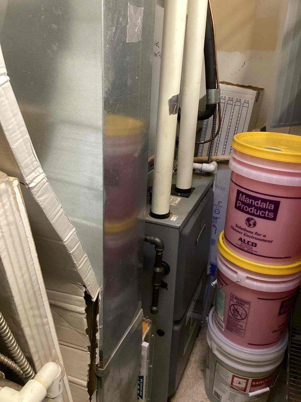 Responded to service call for non-operational commercial A/C unit located in back mechanical space. Upon inspection, found InterLINK compressor model ABA042KAA (R410A refrigerant) showing signs of age with visible corrosion on mounting pan and base components. Evaluated air handler unit, condensate drain lines, and refrigerant line set; confirmed proper drainage and verified system connections. Documented equipment condition including compressor specifications and overall installation for service records.