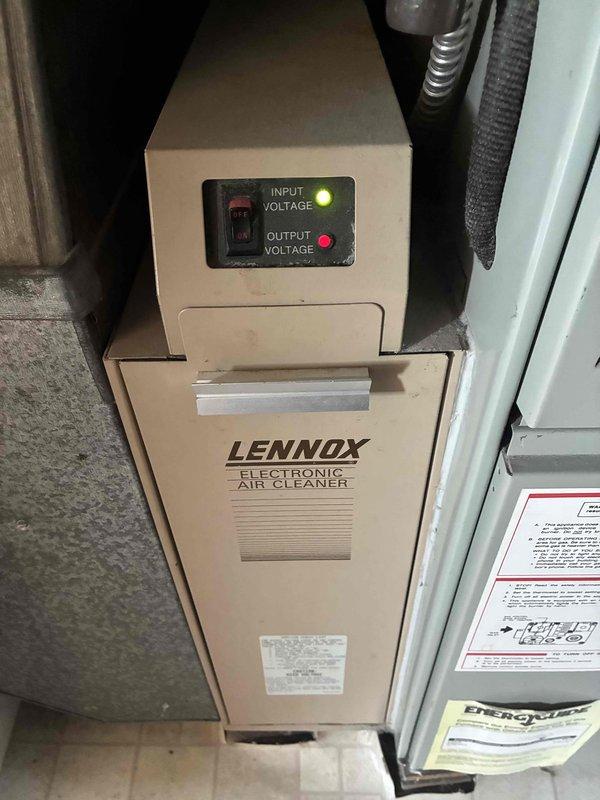 Completed routine cooling system maintenance visit. Inspected and documented PVC condensate drain line installation in attic space, confirming proper securing and functionality. Verified Lennox Electronic Air Cleaner operation with both input and output voltage indicator lights illuminated, confirming unit is functioning correctly within normal parameters.