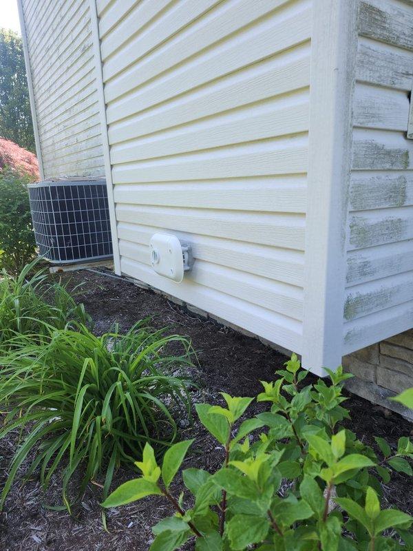 Completed HVAC warranty installation inspection at residential property. Verified proper operation and placement of outdoor condensing unit adjacent to home foundation, confirmed electrical connections to exterior-mounted components, and documented system installation in landscaped area with appropriate clearances maintained per manufacturer specifications.