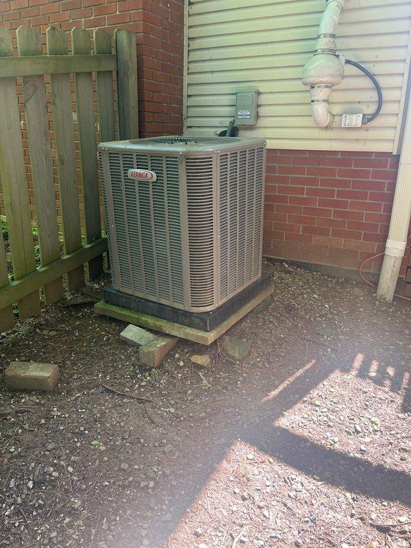 Completed full HVAC system replacement including outdoor condensing unit and indoor air handler. Installed new Lennox condensing unit on existing concrete pad in side yard with proper clearances from fence and structure. Mounted electrical disconnect box on exterior siding with appropriate conduit routing. Connected refrigerant lines from outdoor unit through exterior wall penetration to indoor air handler located in basement utility area. Installed new air handler with insulated refrigerant line sets, PVC condensate drain piping with proper trap and termination, and integrated flexible ductwork connections to existing distribution system. Verified all electrical connections, refrigerant line integrity, and drainage functionality. System tested and operational.