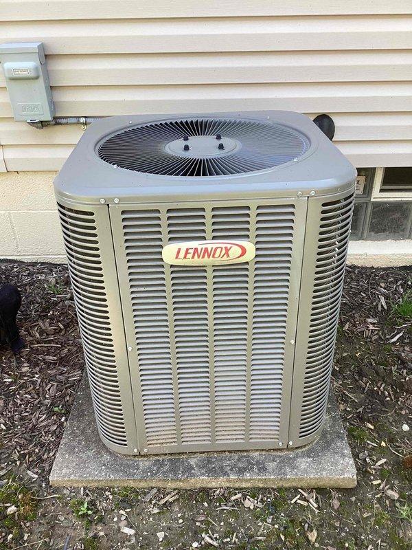 Completed comprehensive spring maintenance on Lennox outdoor condensing unit and associated HVAC system components. Performed standard seasonal inspection protocol including visual assessment of condensing unit exterior condition, electrical disconnect box, refrigerant line connections, and proper unit leveling on concrete pad. Verified outdoor unit operational status with no visible damage or significant wear noted to housing, louvers, or fan grille assembly. Inspected Aprilaire 600 Series humidifier mounted to ductwork in mechanical room, confirming proper installation and electrical connections. Documented equipment condition through photographic record showing both exterior condensing unit and interior humidification system components in functional operating condition. All system components assessed and found operating within normal parameters for seasonal startup.