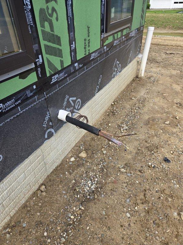 Completed commercial HVAC new construction installation at multi-story building site. Coordinated rough-in work with general contractor during exterior envelope phase, installing refrigerant line sets and condensate drain piping through foundation penetrations while building was wrapped with ZIP System weather barrier and foam insulation. All penetrations were properly sealed and coordinated with weatherproofing schedule to maintain building envelope integrity.