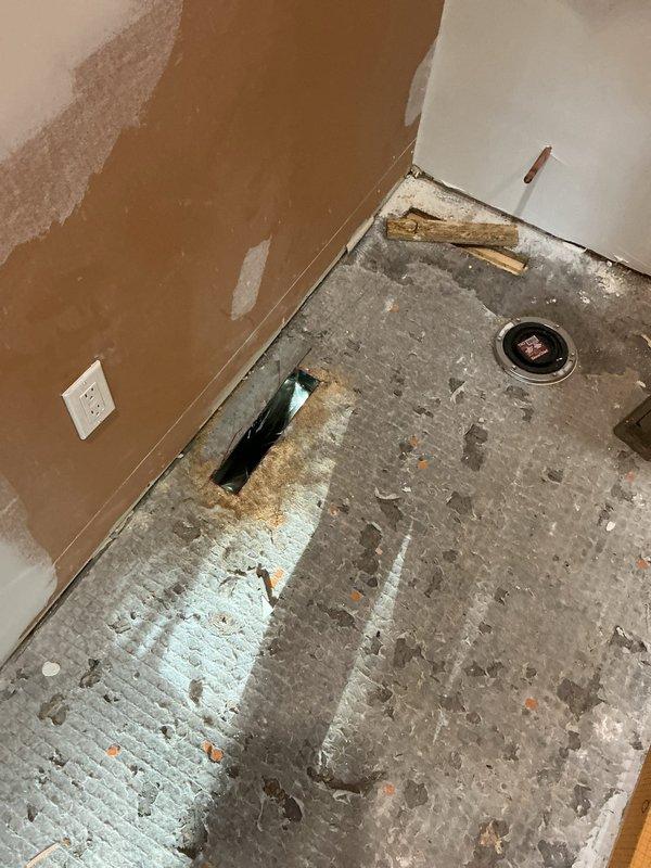 Completed installation of ductwork for master bathroom in new construction project. Installed stainless steel duct runs with elbow joints and rectangular plenum connection, routing through basement ceiling joists to serve bathroom area. Left two registers on site as requested for final installation phase.