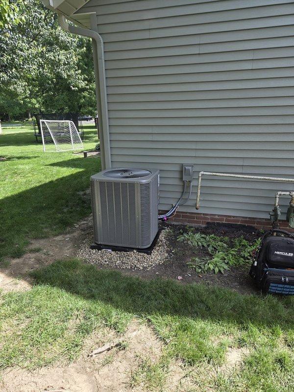 Completed full AC retrofit installation at residential property. Installed new outdoor condensing unit on gravel pad with proper refrigerant line connections to exterior wall, and replaced indoor evaporator coil integrated with existing furnace system in basement. Unit positioned on stable foundation with appropriate clearances, copper linesets properly insulated and routed through exterior wall penetration. Indoor coil installation completed with secure mounting to air handler, verified proper airflow through ductwork, and confirmed all electrical connections meet code requirements. System tested for proper refrigerant charge, verified temperature differential across coil, and confirmed unit operates within manufacturer specifications.