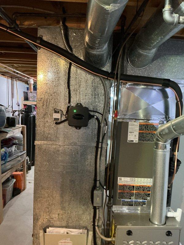 Completed full AC retrofit installation at residential property. Installed new outdoor condensing unit on gravel pad with proper refrigerant line connections to exterior wall, and replaced indoor evaporator coil integrated with existing furnace system in basement. Unit positioned on stable foundation with appropriate clearances, copper linesets properly insulated and routed through exterior wall penetration. Indoor coil installation completed with secure mounting to air handler, verified proper airflow through ductwork, and confirmed all electrical connections meet code requirements. System tested for proper refrigerant charge, verified temperature differential across coil, and confirmed unit operates within manufacturer specifications.