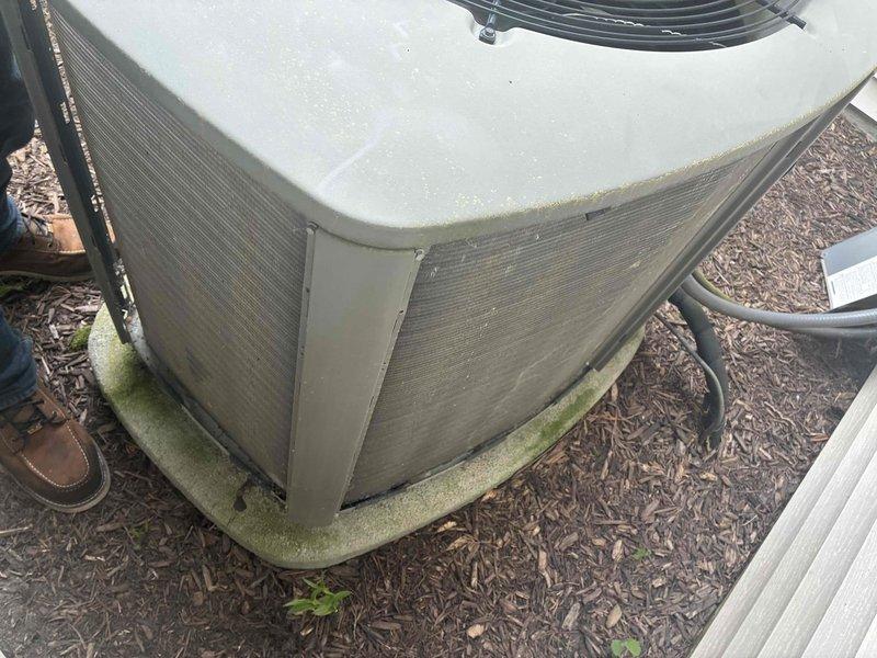 Completed comprehensive AC tune-up on 20-year-old air conditioning system. Inspected outdoor condenser unit, noting weathering and minor algae growth on casing and base pad. Verified proper airflow direction on 20x25x5 air filter assembly within ductwork, documented filter replacement date, and confirmed thermostat control operation. System operational and functioning within normal parameters for unit age.