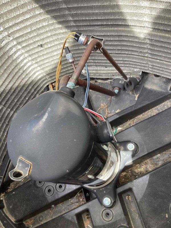 Responded to no cooling complaint on commercial air conditioning unit. Upon arrival, inspected compressor assembly model SBA040B3CPA and associated refrigerant lines. Found compressor mounted on outdoor condensing unit with visible signs of weathering and debris accumulation around base. Examined copper refrigerant lines with white insulation material and electrical connections including control wiring. Assessed overall condition of unit components including mounting brackets, piping connections, and electrical terminations. Documented equipment condition with photographs showing compressor label with technical specifications, refrigerant line routing, and internal cabinet configuration with corrugated metal housing. Unit components appeared intact with typical operational wear patterns consistent with commercial outdoor installation.
