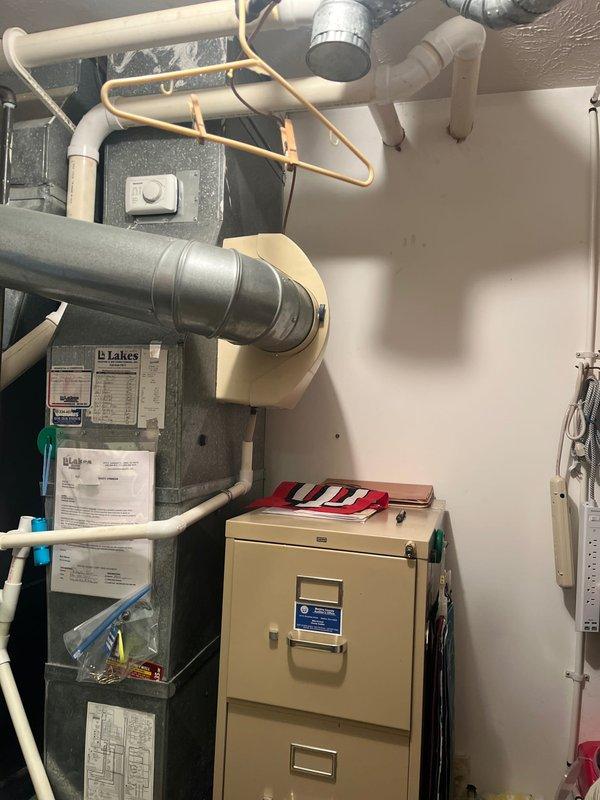 Completed comprehensive HVAC system evaluation for residential air conditioning replacement estimate. Documented existing outdoor condenser unit positioned on concrete pad against exterior wall and indoor air handler installation in mechanical room, including all associated refrigerant lines, ductwork, PVC drainage systems, and electrical connections to provide accurate replacement specifications and equipment recommendations.