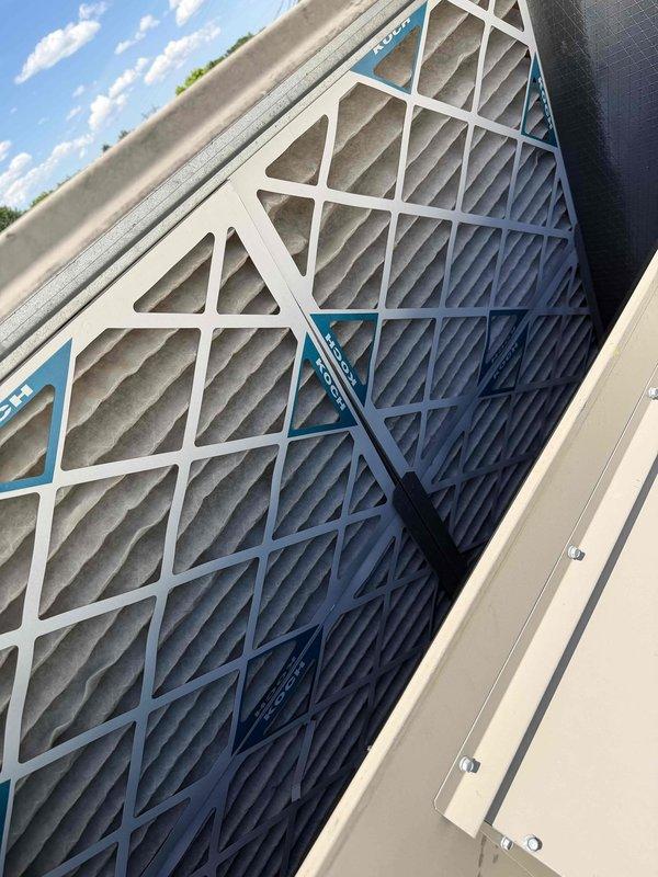 Completed scheduled commercial cooling maintenance visit on rooftop HVAC unit. Inspected multi-filter air filtration assembly and noted moderate dust and debris accumulation across pleated filters with varying levels of loading. Accessed electrical control panel and verified wiring connections, contactors, and safety disconnect functionality. All electrical components operating within normal parameters with warning labels intact and visible.
