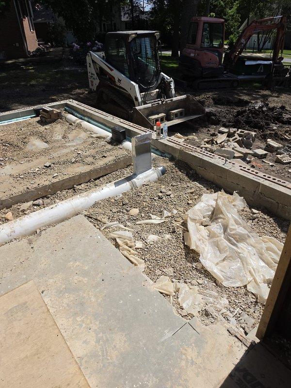 Completed HVAC rough-in installation for new residential construction foundation phase. Coordinated underground ductwork placement and drainage line routing through freshly poured concrete slab and foundation walls, ensuring proper clearances and structural penetrations per building specifications. All rough-in components positioned and verified before concrete finishing and framing phases commence.