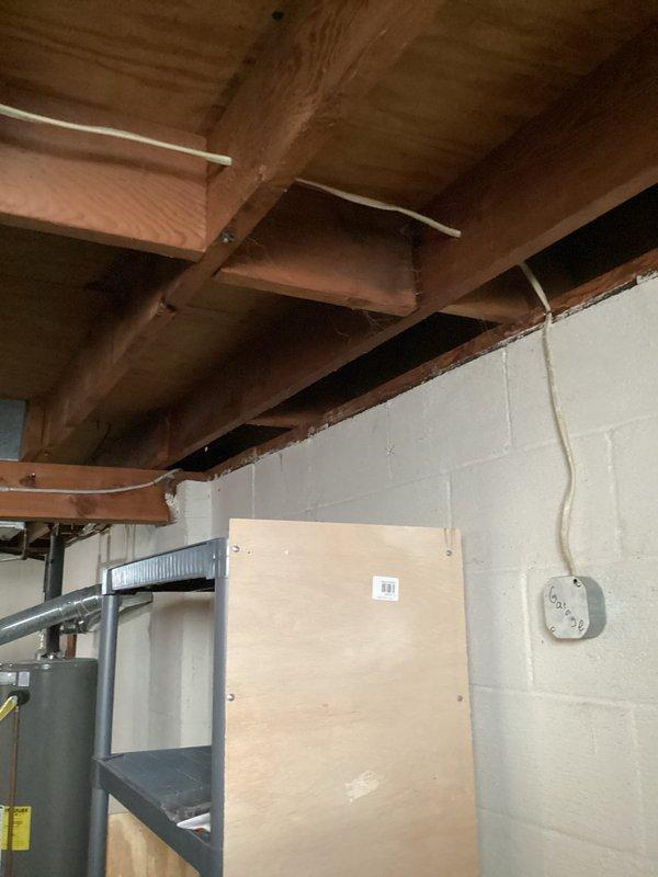 Replumbed backyard spigot connection to main water supply line in basement crawl space. Installed new black supply pipe with shutoff valve and hose connection, securing all components to cinder block foundation wall per code requirements.