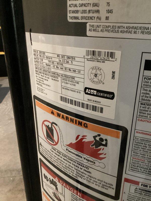 Responded to reported hot water tank leak at residential property. Upon inspection, identified active leak condition on 75-gallon capacity water heater unit manufactured in Mexico with AHRI certification. Assessed expansion tank, copper piping connections, and associated brass fittings for integrity and proper operation. Documented equipment specifications, including thermal efficiency rating of 80% and standby loss of 1045 BTU/HR. Verified installation compliance with ASHRAE/IESNA standards and confirmed all safety warning labels were properly displayed regarding flammable vapor hazards. Photographed equipment configuration showing expansion tank mounting, copper supply lines with visible solder joints, circulation pump assembly, and related plumbing connections for service records.