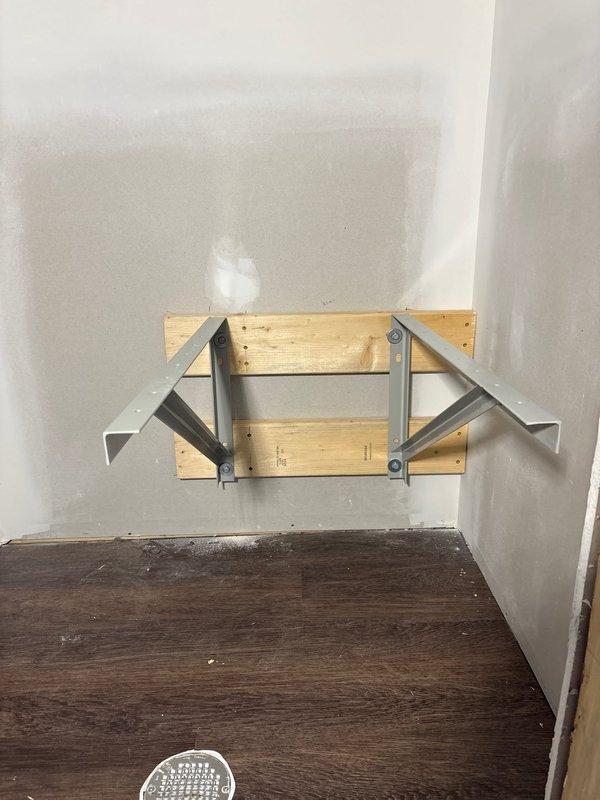 Installed structural wall bracing and metal mounting brackets to support air handler units in new construction space. Secured L-bracket supports to wall studs with appropriate fasteners to ensure proper load-bearing capacity for equipment installation.