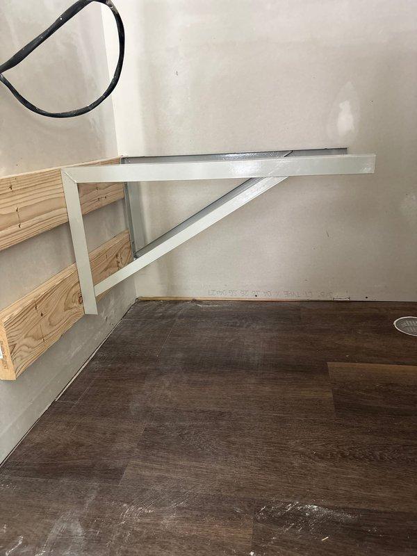 Installed structural wall bracing and metal mounting brackets to support air handler units in new construction space. Secured L-bracket supports to wall studs with appropriate fasteners to ensure proper load-bearing capacity for equipment installation.