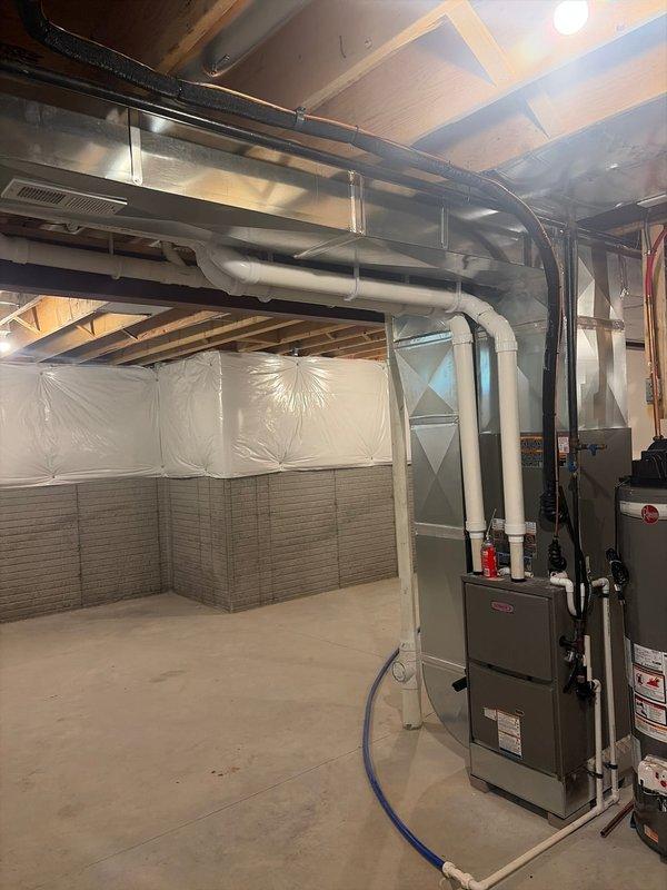 Completed new construction HVAC system startup in basement mechanical room after addressing refrigerant line installation issues. Verified proper refrigerant line routing and connections for gray furnace unit, ensured all ductwork connections were secure, and confirmed PVC drainage piping was properly installed. Successfully started up the system, tested all components for proper operation, and verified adequate airflow through the metallic ductwork running throughout the space.