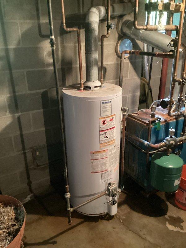 Responded to no hot water emergency call and provided installation estimate for customer-supplied 50-gallon gas water heater. Assessed existing basement utility room configuration including current water heater, plumbing connections, gas supply lines, venting requirements, and surrounding equipment including expansion tank and water treatment system. Evaluated copper supply piping, pressure relief valve placement, and drainage provisions. Documented existing installation with photographs showing water heater positioning against concrete block wall, overhead plumbing connections, and adjacent mechanical equipment. Provided comprehensive quote for complete water heater replacement including removal of old unit, installation of new 50-gallon gas water heater with proper venting, connection of hot and cold water lines, gas line hookup, installation of new temperature and pressure relief valve with proper drainage, and testing of all connections for leaks and proper operation.