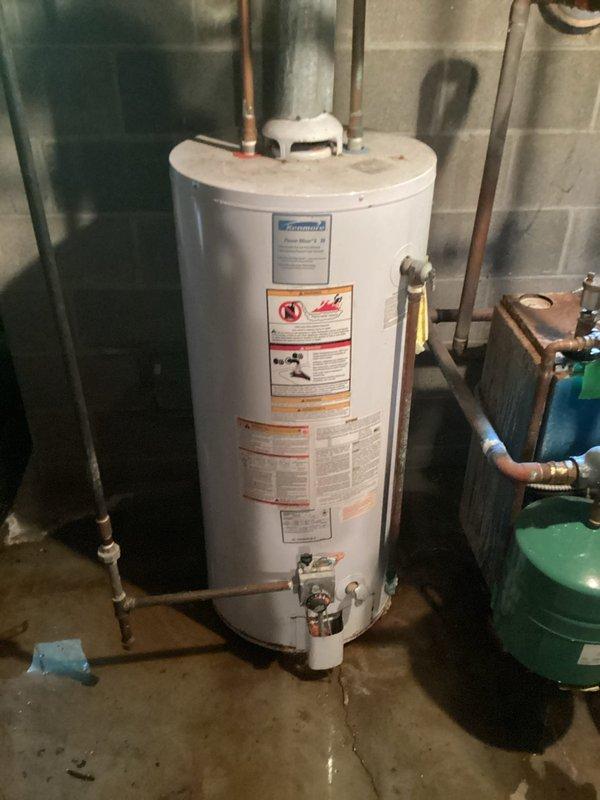 Responded to no hot water emergency call and provided installation estimate for customer-supplied 50-gallon gas water heater. Assessed existing basement utility room configuration including current water heater, plumbing connections, gas supply lines, venting requirements, and surrounding equipment including expansion tank and water treatment system. Evaluated copper supply piping, pressure relief valve placement, and drainage provisions. Documented existing installation with photographs showing water heater positioning against concrete block wall, overhead plumbing connections, and adjacent mechanical equipment. Provided comprehensive quote for complete water heater replacement including removal of old unit, installation of new 50-gallon gas water heater with proper venting, connection of hot and cold water lines, gas line hookup, installation of new temperature and pressure relief valve with proper drainage, and testing of all connections for leaks and proper operation.