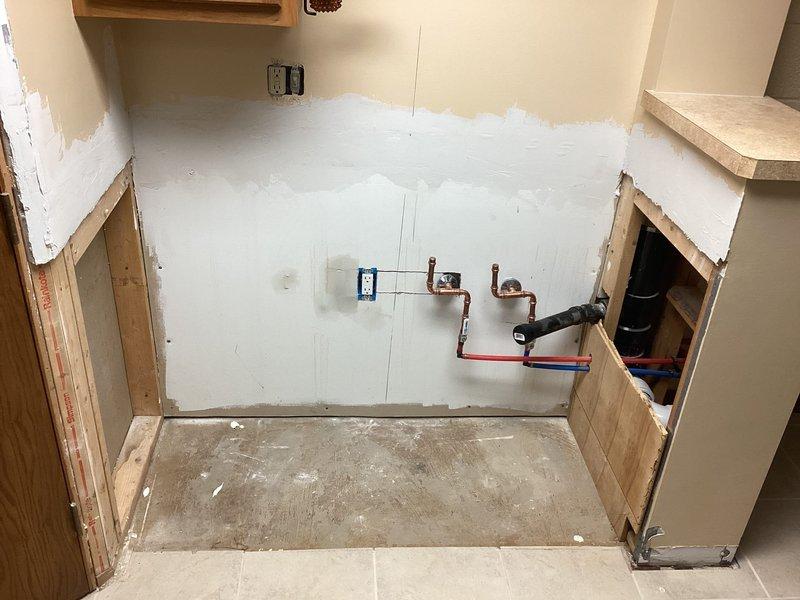 Conducted site assessment for ice maker installation in basement/utility area. Inspected existing plumbing rough-in with copper supply line stubs and PEX shut-off valves protruding from wall. Documented current conditions including exposed framing, unfinished drywall, and accessible water supply connections to determine requirements for completing ice maker hookup.